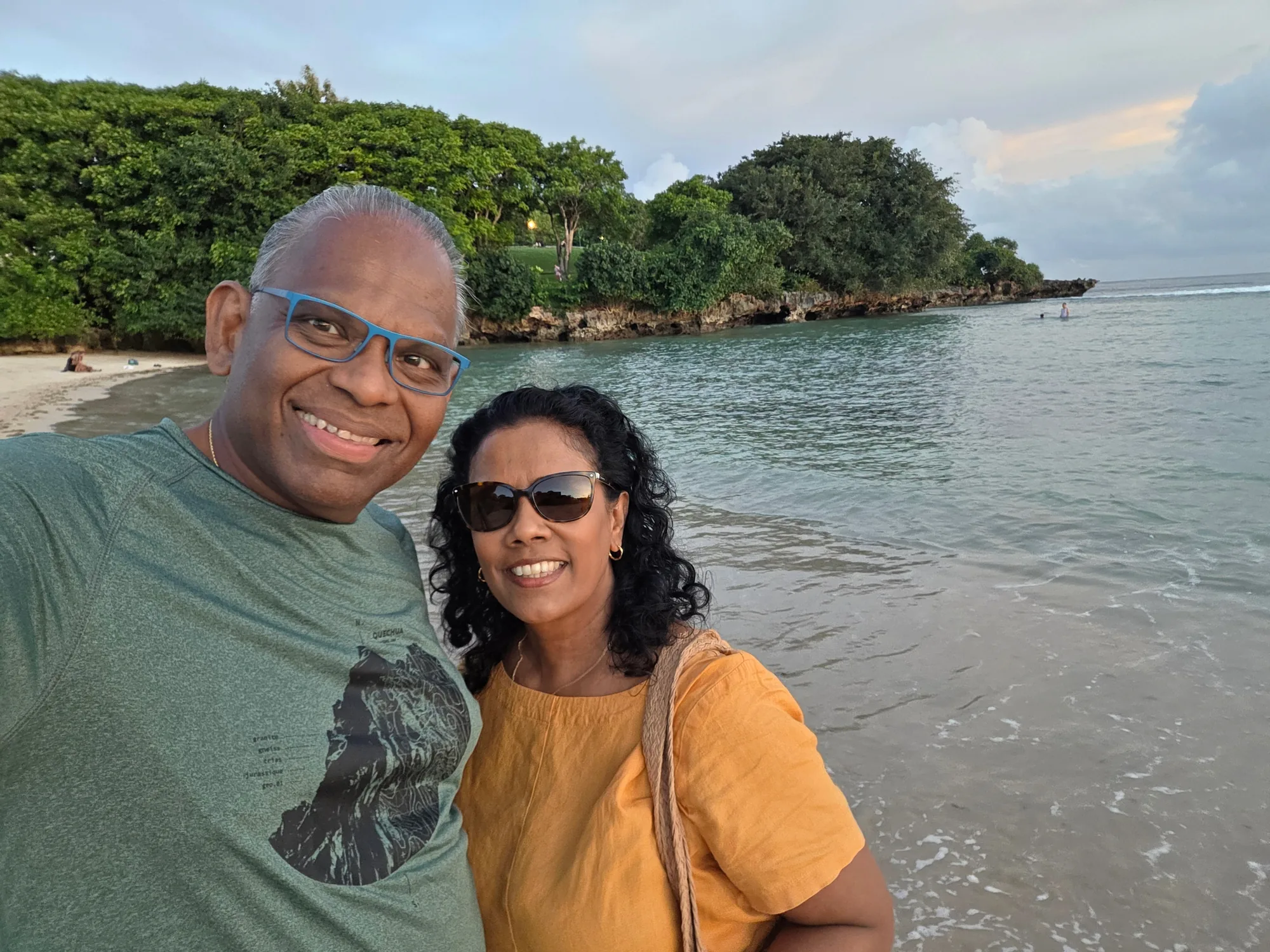 A couple taking a selfie beside a tropical beach